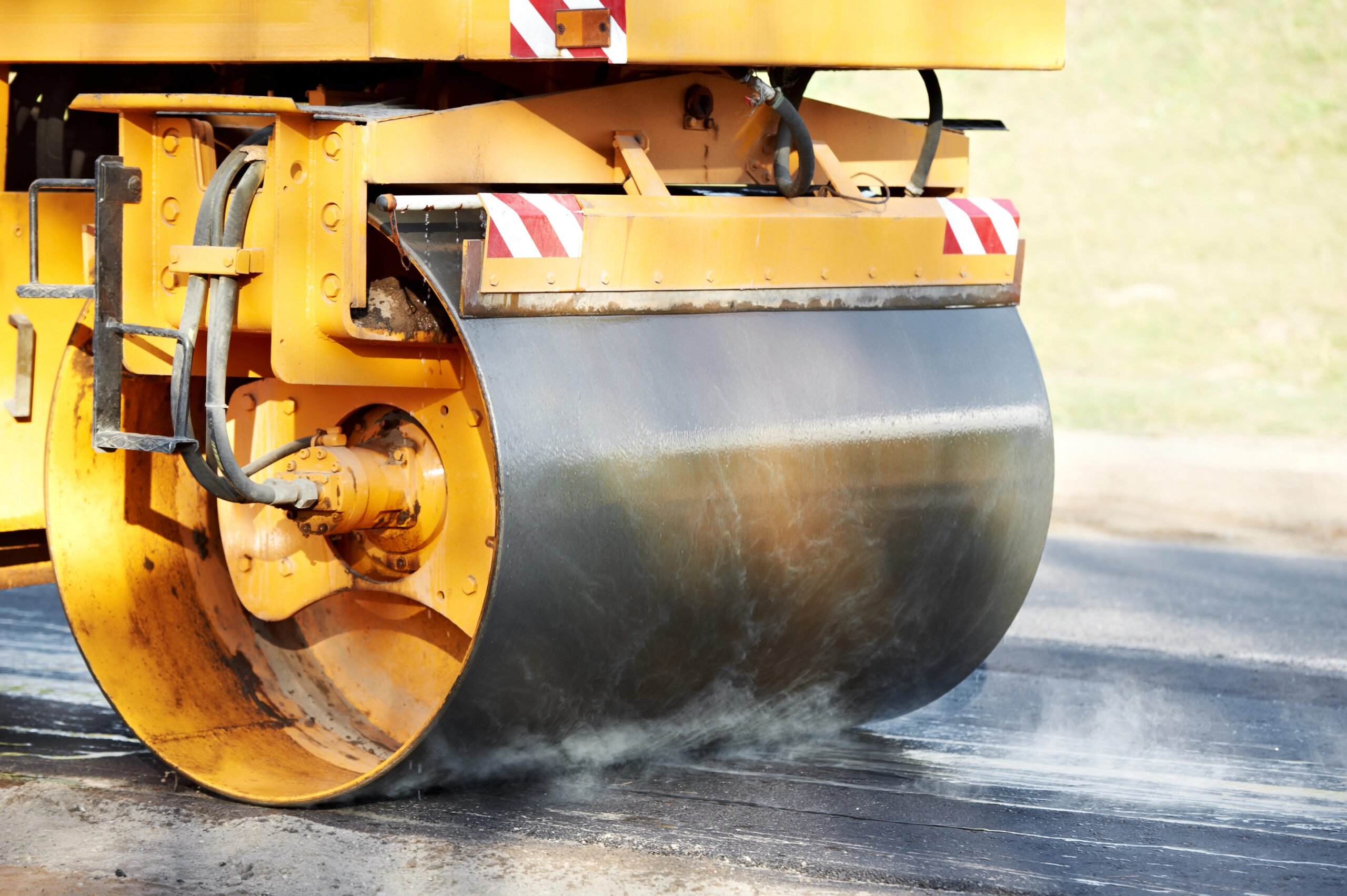 Heavy vibration roller compacting freshly poured asphalt