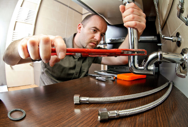 A close-up of a plumber handyman at work