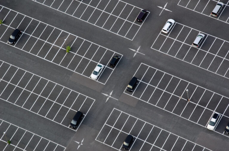 A clean parking lot seen from above with many empty parking spaces.